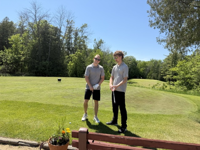 Golfers posed at the tee